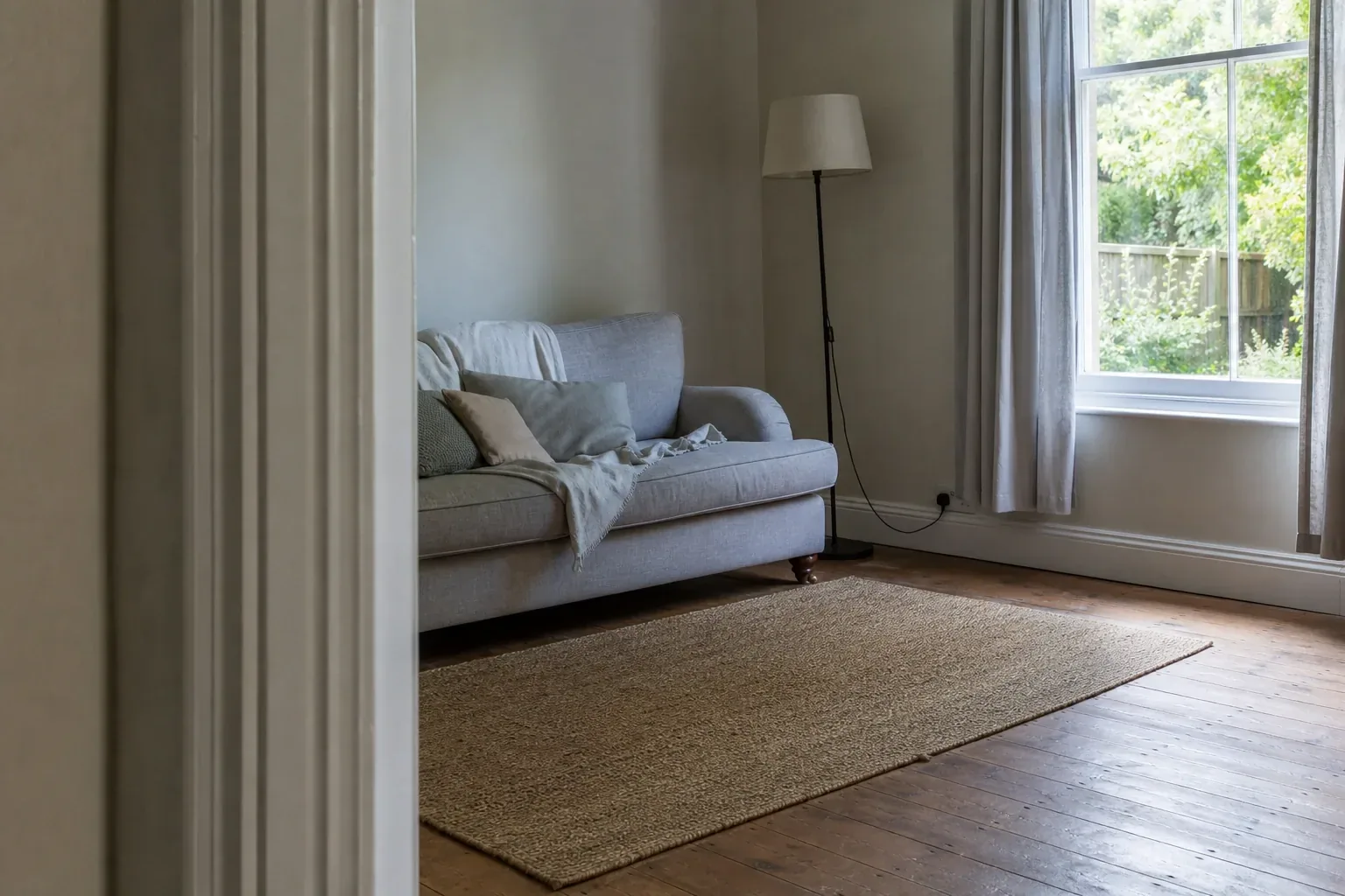 View into a furnished living room from the doorway with the doorframe edge in the foreground