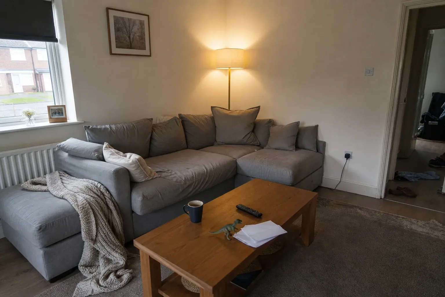 A lived-in family living room with a sectional sofa, scattered toys and opened mail on the coffee table